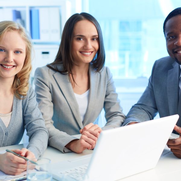 Group of happy businesspeople looking at camera with smiles